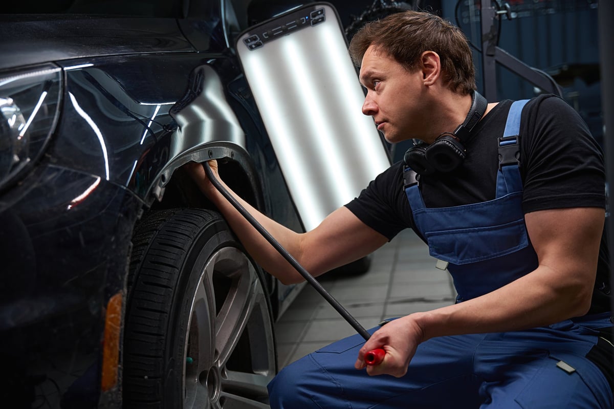 Panel-beater unbending motor vehicle front fender using a dent removal rod
